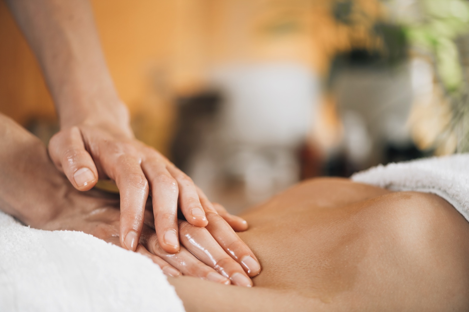 Warme, rustige massageruimte met zacht licht en natuurlijke tinten, een uitnodiging om tot rust te komen